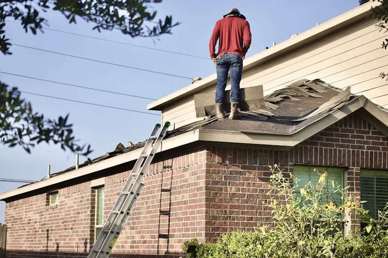Professional roofer working on a residential roof in Goffstown